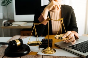 female-lawyer-in-office-holds-scales-of-justice