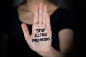 woman-with-stop-clergy-predators-written-on-her-hand