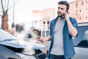 upset man calling for roadside service after crash