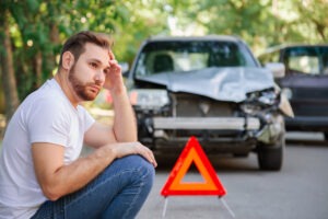 upset man waiting for help after a crash