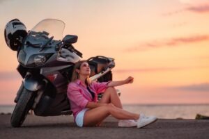 young woman relaxing next to her motorcycle in bloomfield