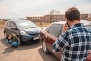 A man on the phone after a car accident. Michigan PIP coverage: what you need to know
